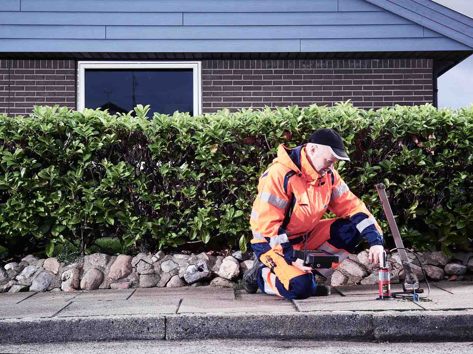 Montør laver lækagesøgning på vand under vejen
