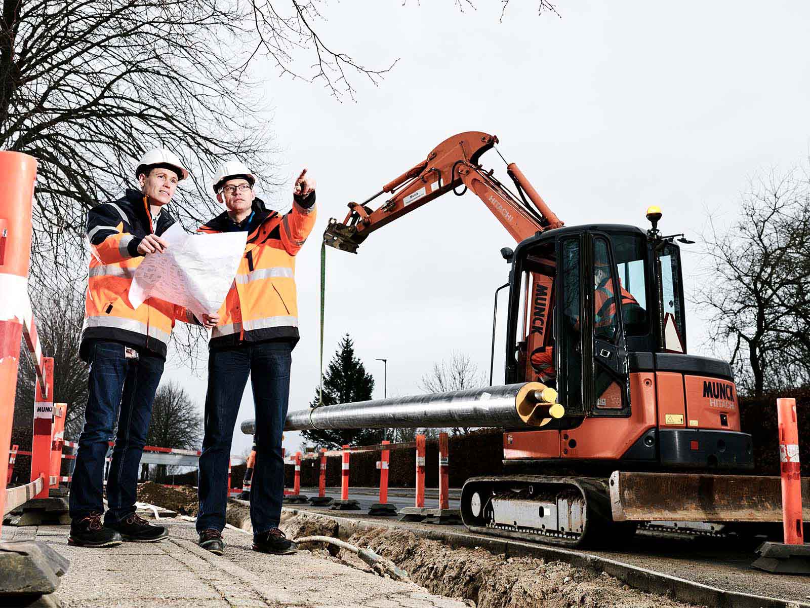 Projektledere står foran minigraver