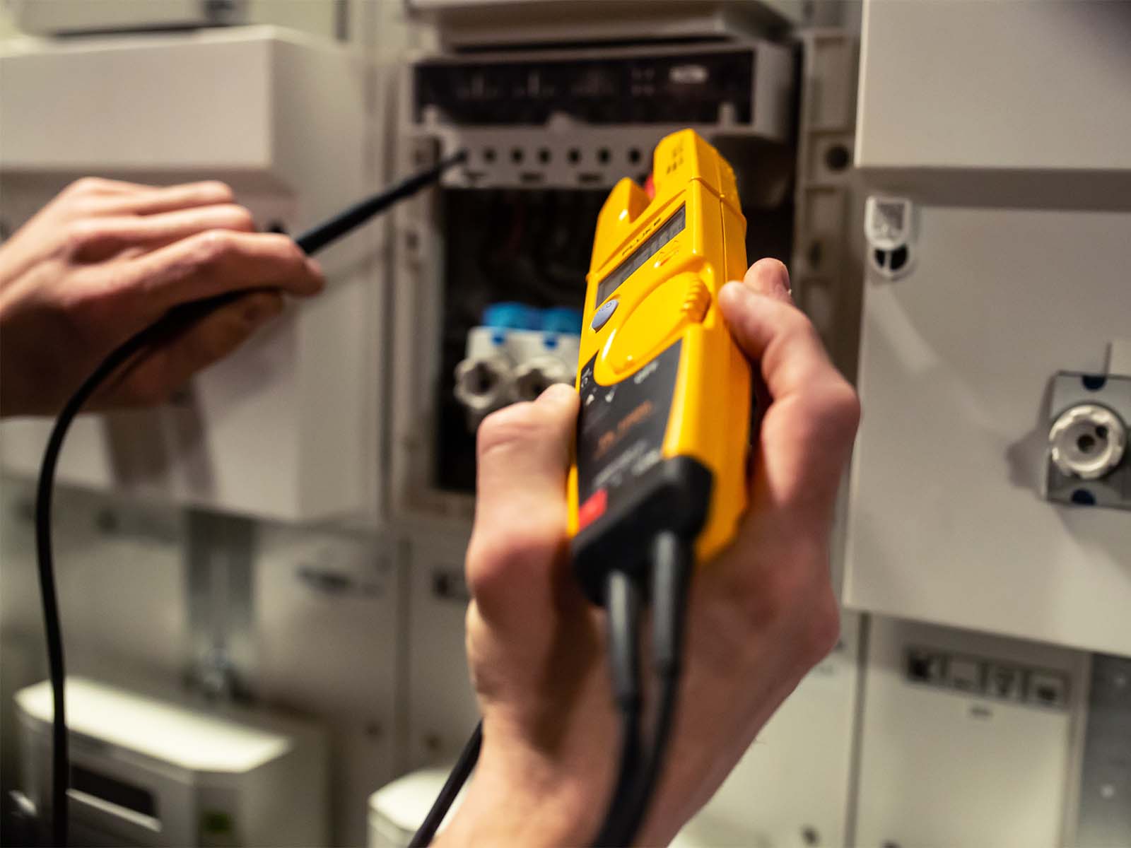 Elektriker måler strøm ved elskab